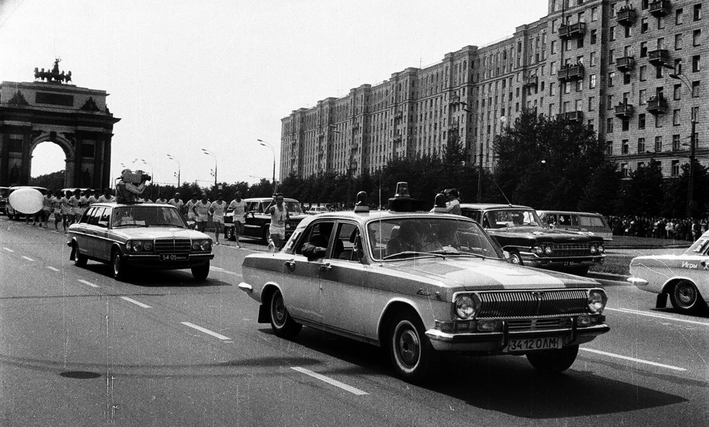 Олимпийский огонь на улицах Москвы. В колонне — удлиненный Mercedes-Benz W123 с люком для кинооператора.